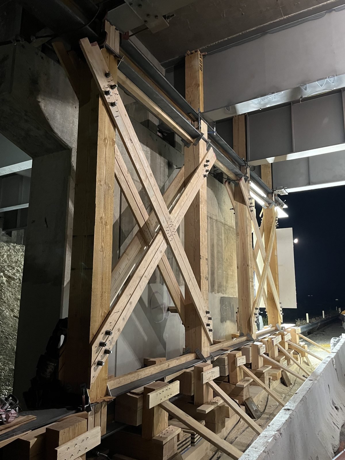 Timber jacking bent with steel caps under the girders of an existing freeway overcrossing