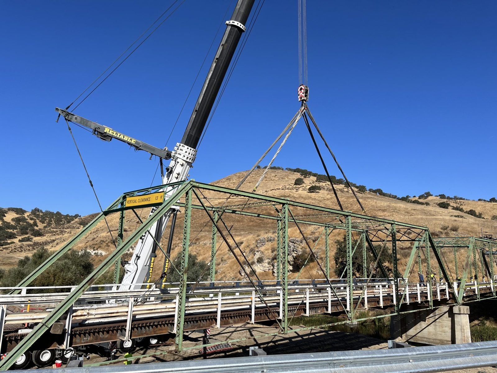 Crane lifting a 1921 steel truss bridge span during demolition